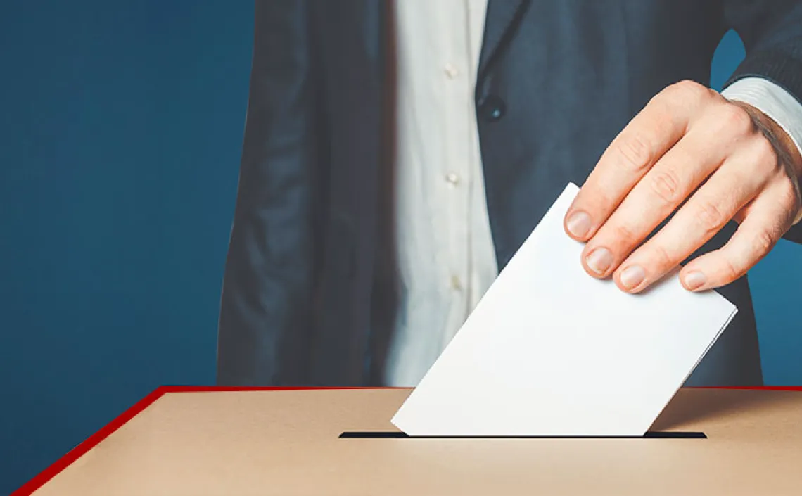 A man casting a ballot in a ballot box